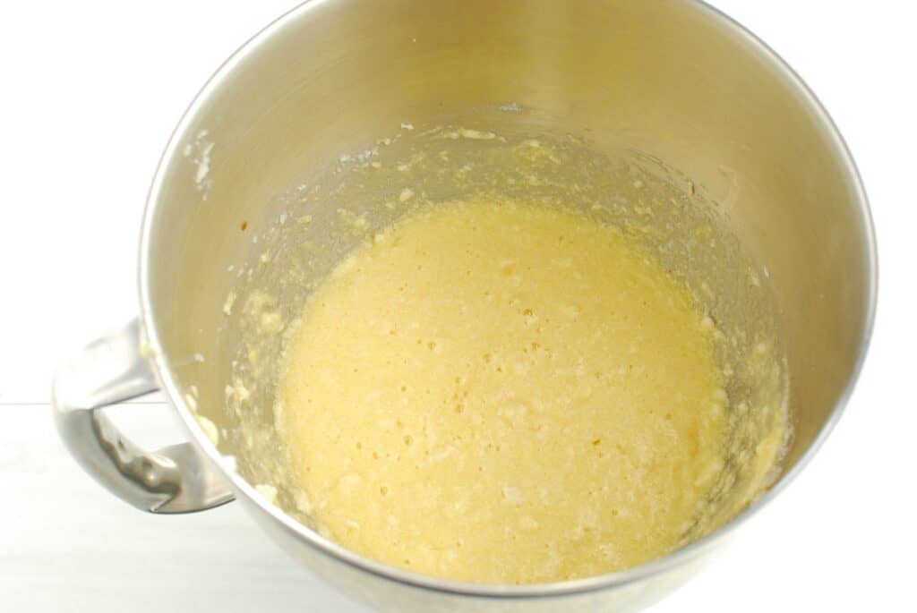 Mixing bowl with butter, sugar, eggs, vanilla, and coconut extract mixed together.