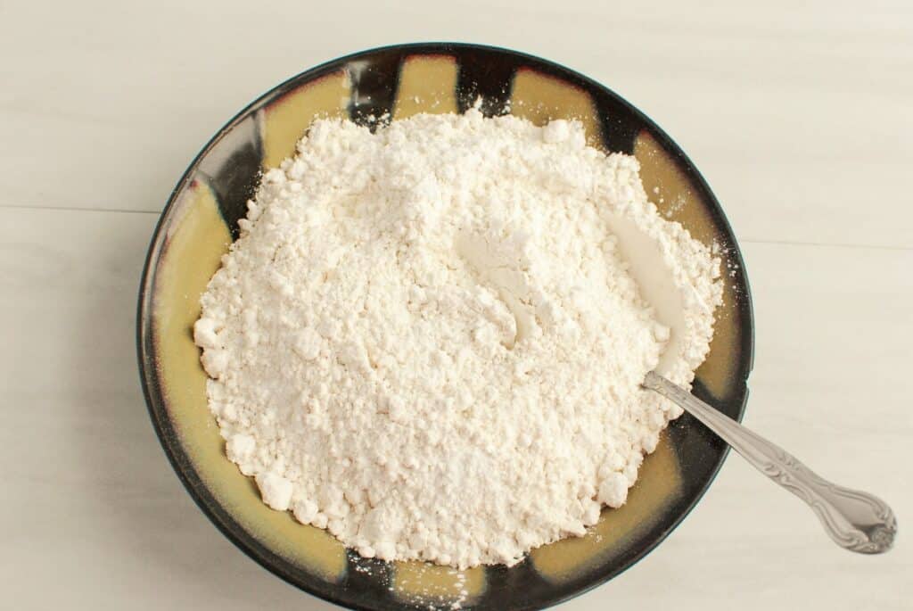 Flour, baking powder, and salt mixed together in a bowl.