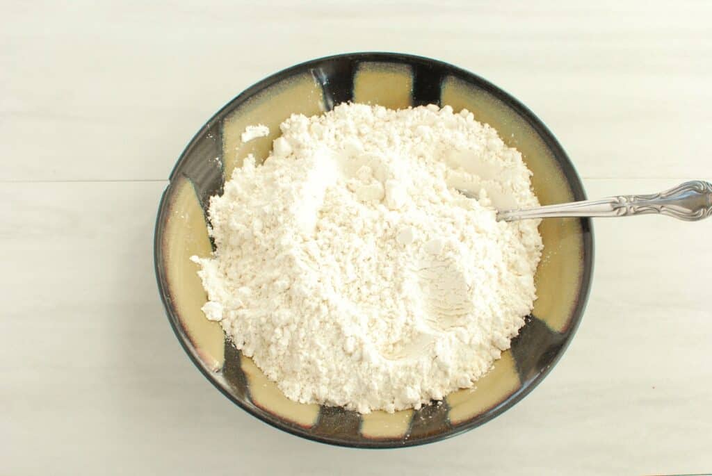 Flour, baking soda, and salt mixed together in a bowl.