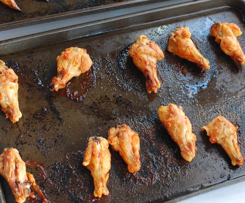 Cooked chicken wings on a baking sheet.