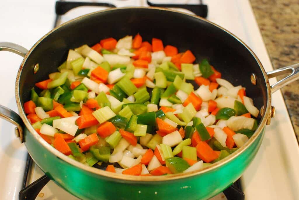 Onions, pepper, carrots, and celery in a sauté pan.