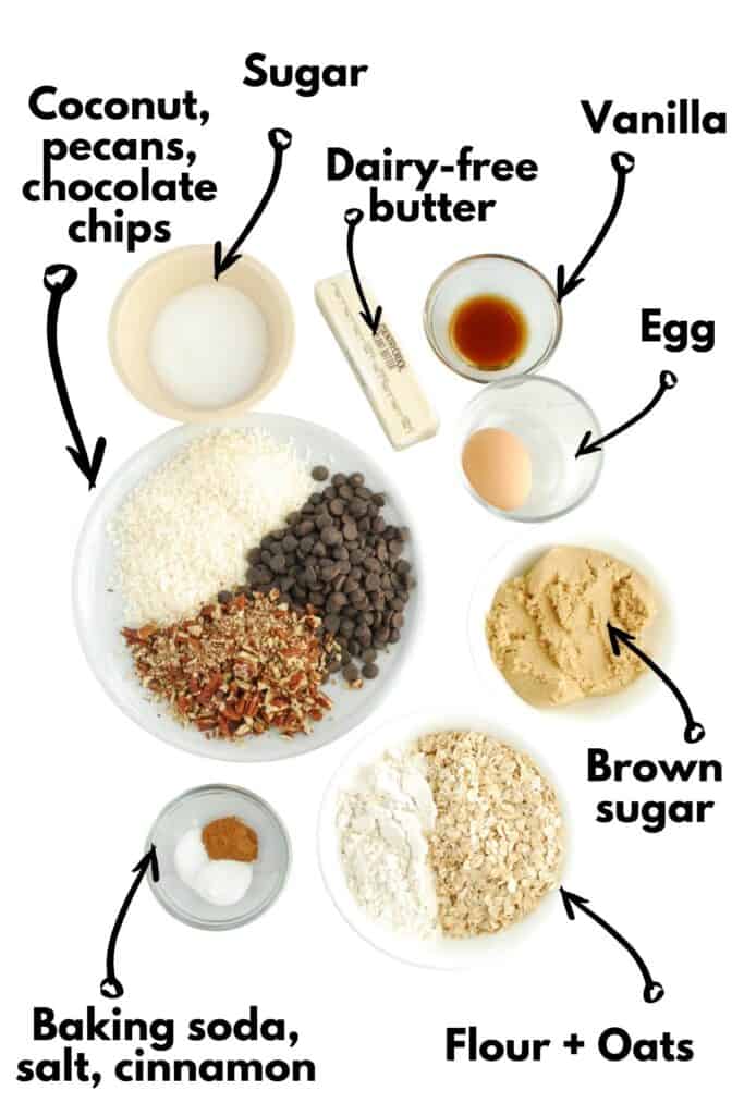 Flour, oats, baking soda, salt, cinnamon, brown sugar, sugar, vanilla, egg, dairy-free butter, coconut, pecans, and chocolate chips.