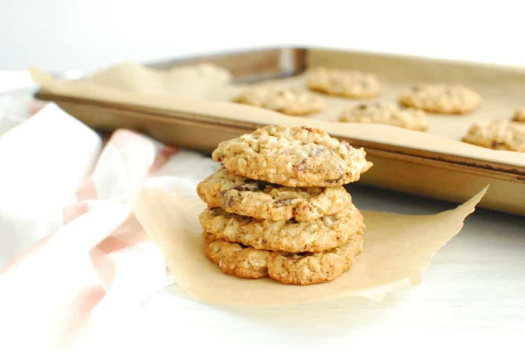 A stack of four dairy free cowboy cookies on a little bit of parchment paper.