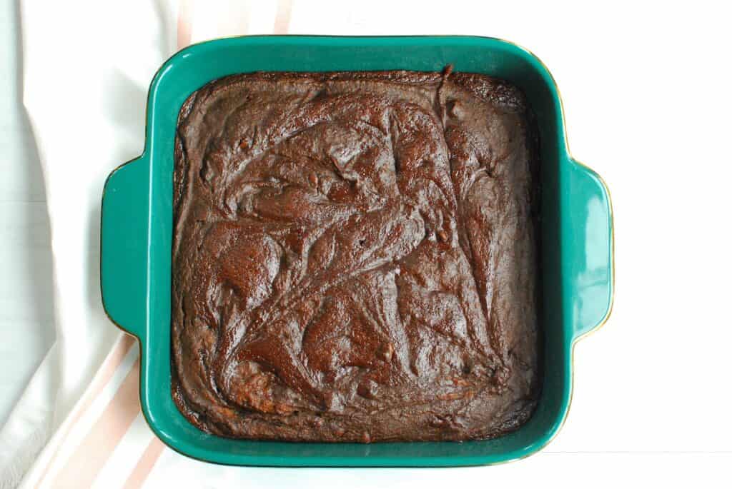 An 8x8 dish with baked brownies in it.