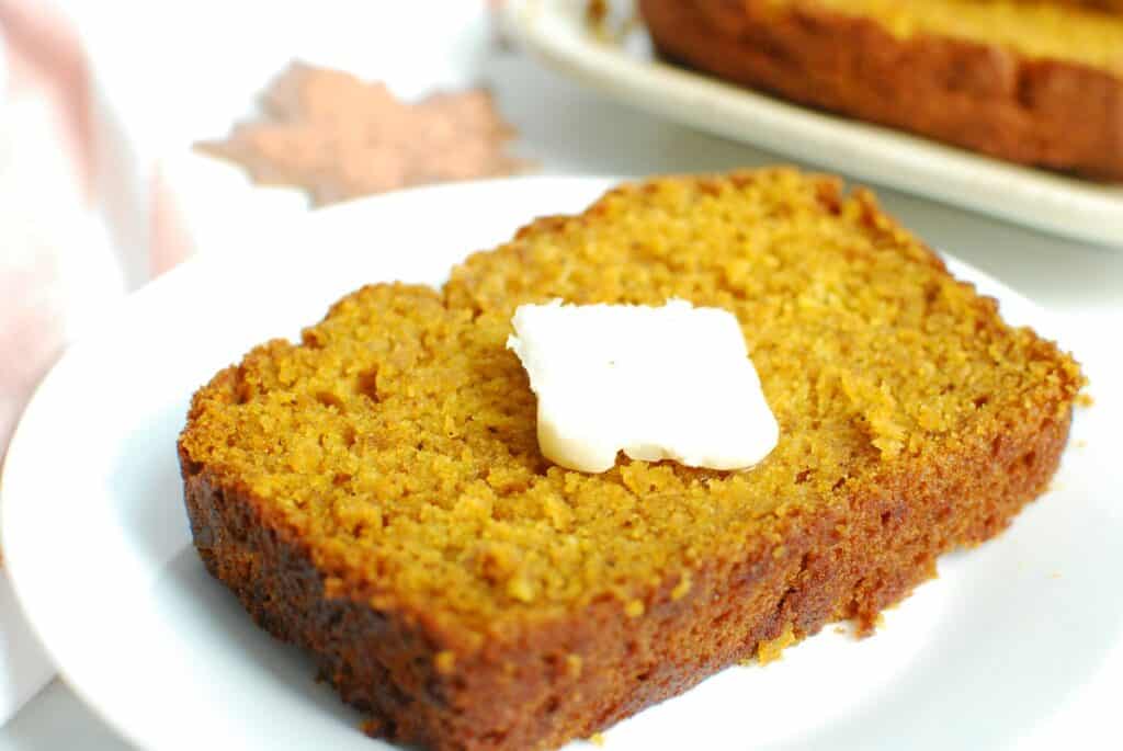 A slice of pumpkin bread topped with dairy-free butter.