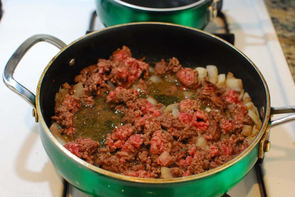 Ground beef and onion in a sauté pan.