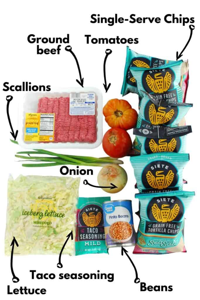 Ground beef, lettuce, scallions, taco seasoning, beans, onion, tomatoes, and chips.