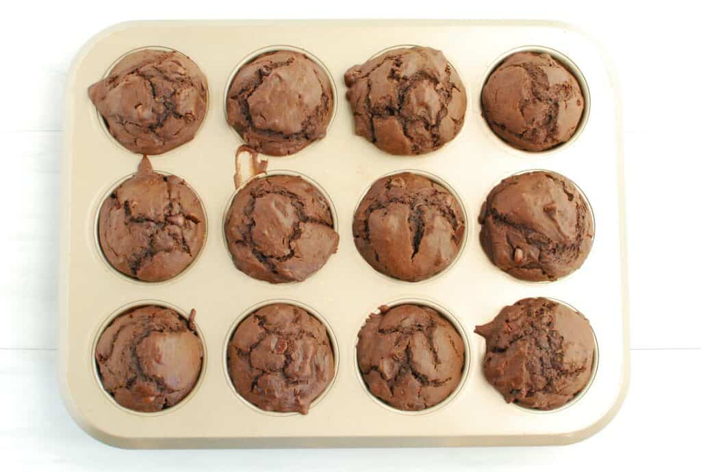 A muffin tin with freshly baked dairy free double chocolate muffins.