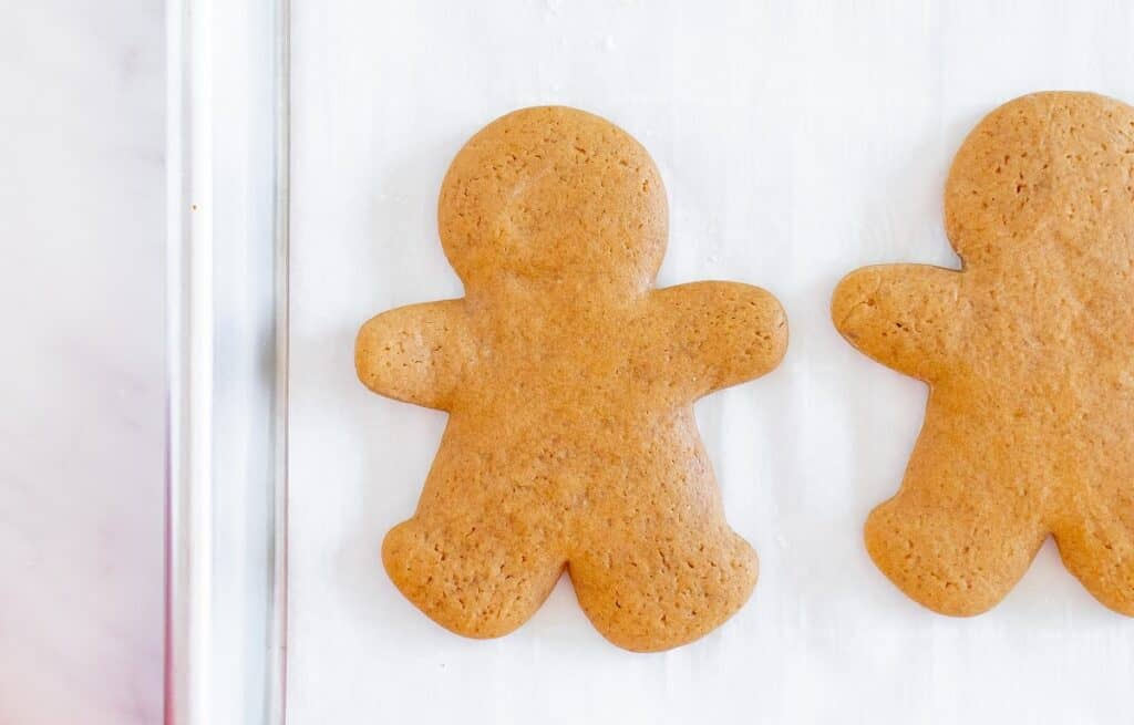 Baked dairy free gingerbread cookies on a parchment-lined baking sheet.