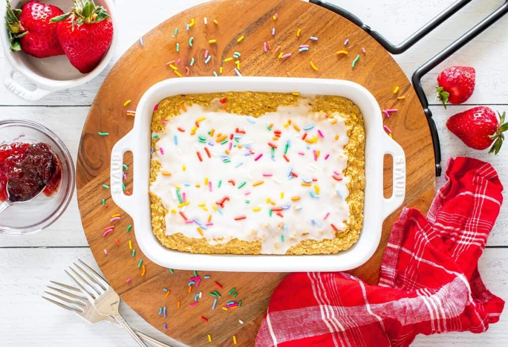 A wooden platter with a dish of dairy free pop tart baked oatmeal on top.
