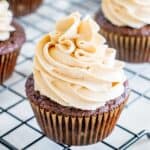 Dairy free peanut butter frosting on a chocolate cupcake on a cooling rack.