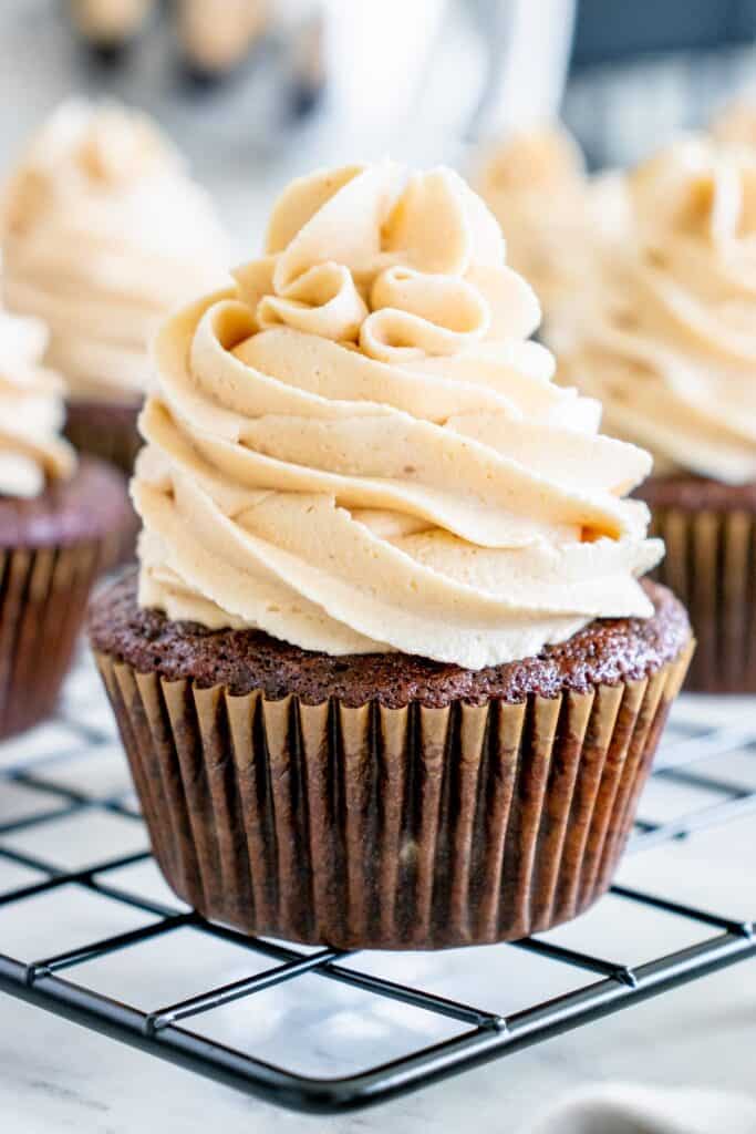 A close up of a dairy free chocolate cupcake topped with peanut butter frosting.