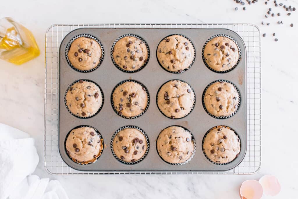 A muffin tin with just-baked dairy free olive oil banana muffins.