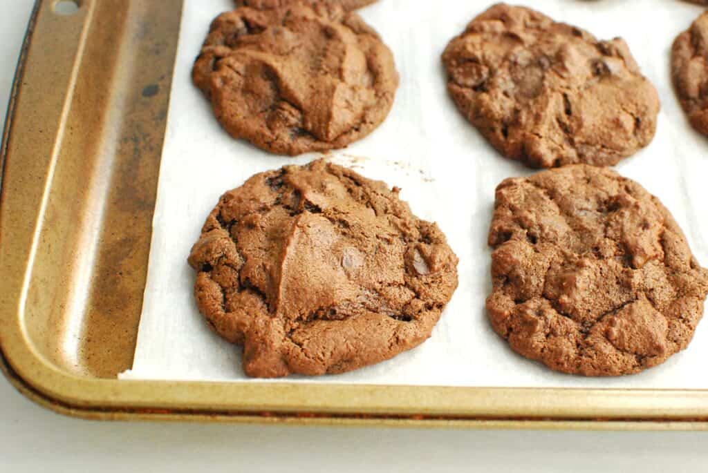 A dairy free chocolate chip cookie on a parchment-lined baking sheet.