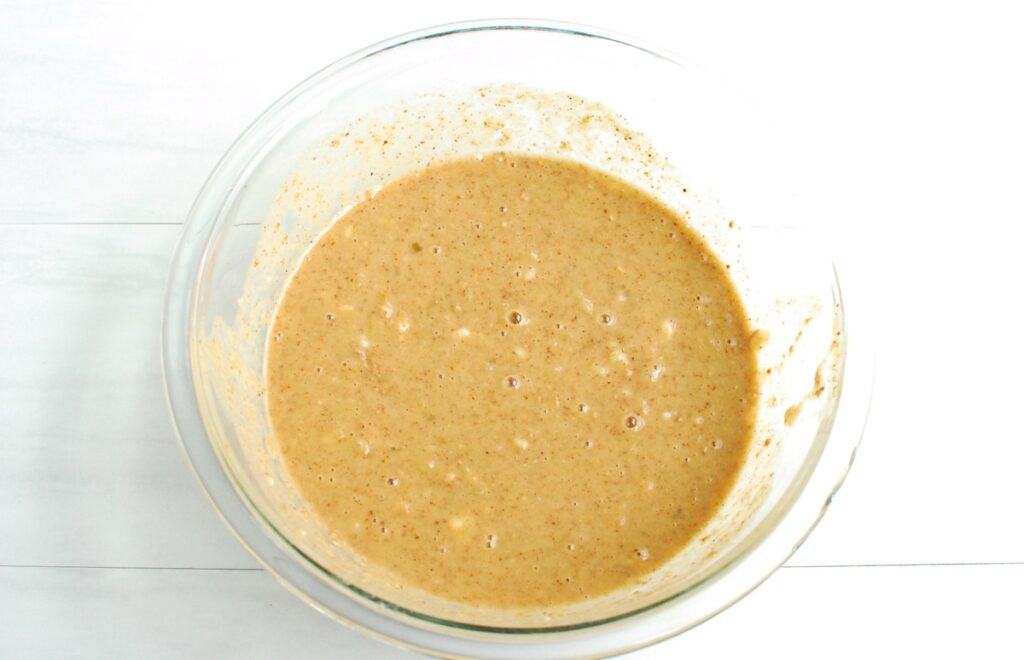 The liquid ingredients for the muffins mixed together in a glass mixing bowl.