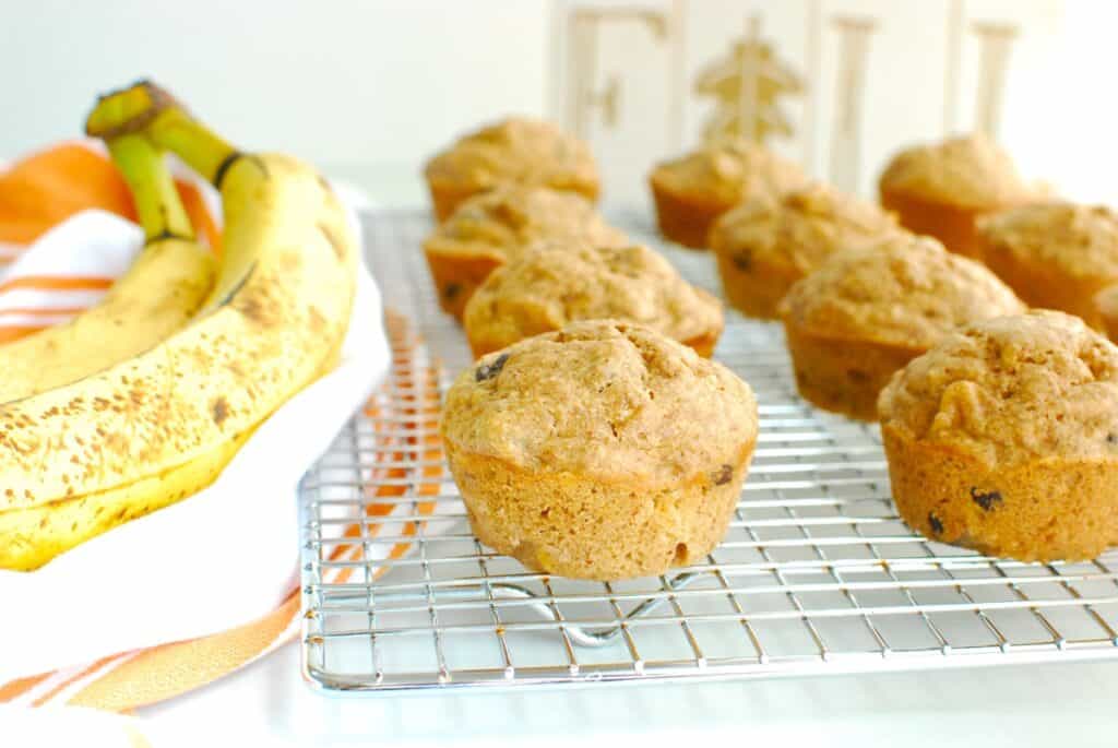 Almond butter banana muffins on a cooling rack, next to a napkin.