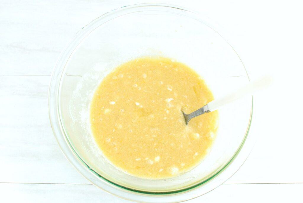 Dairy-free butter, sugar, oat milk, eggs, and vanilla mixed together in a glass bowl.