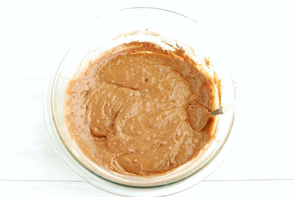 Brownie batter in a glass mixing bowl.