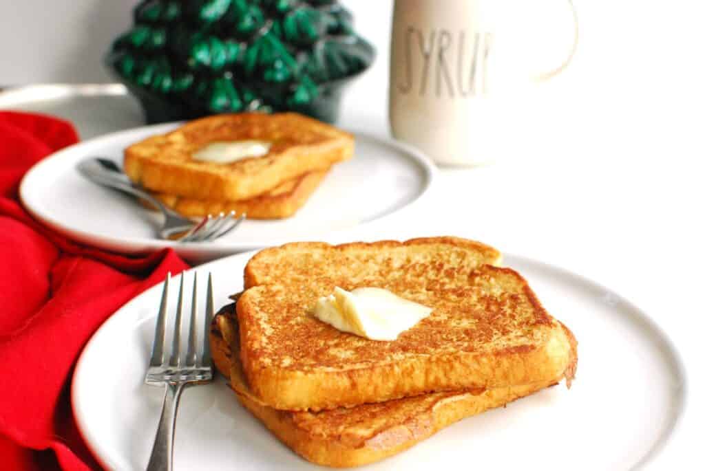 Two slices of french toast with a pat of melting butter on top.