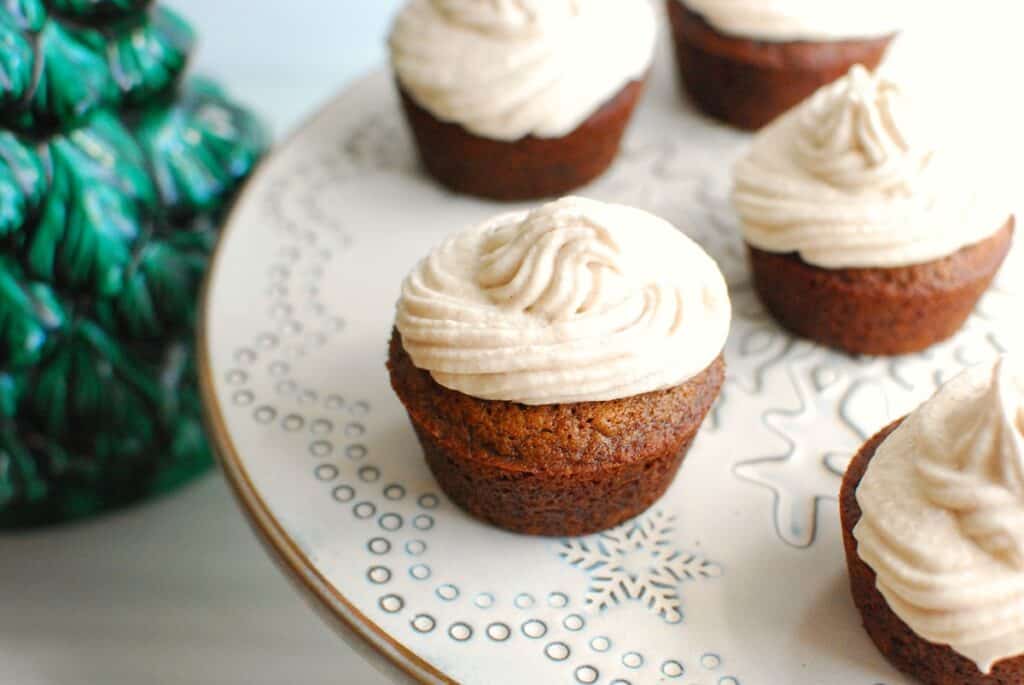 Several dairy free gingerbread cupcakes on a cake stand.