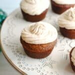 A dairy free gingerbread cupcake topped with frosting on a cupcake stand.