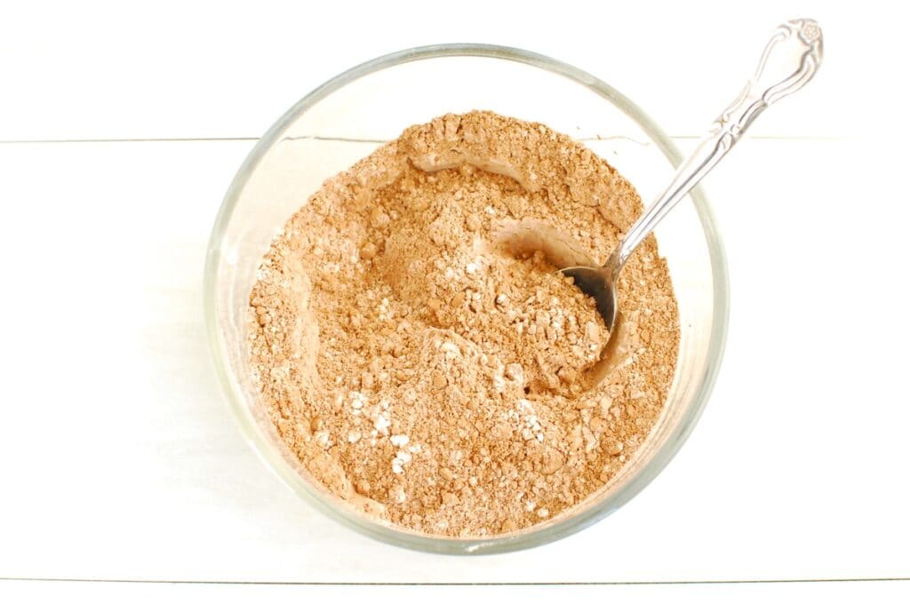 Flour, cocoa powder, ginger, cinnamon, and salt mixed together in a bowl.