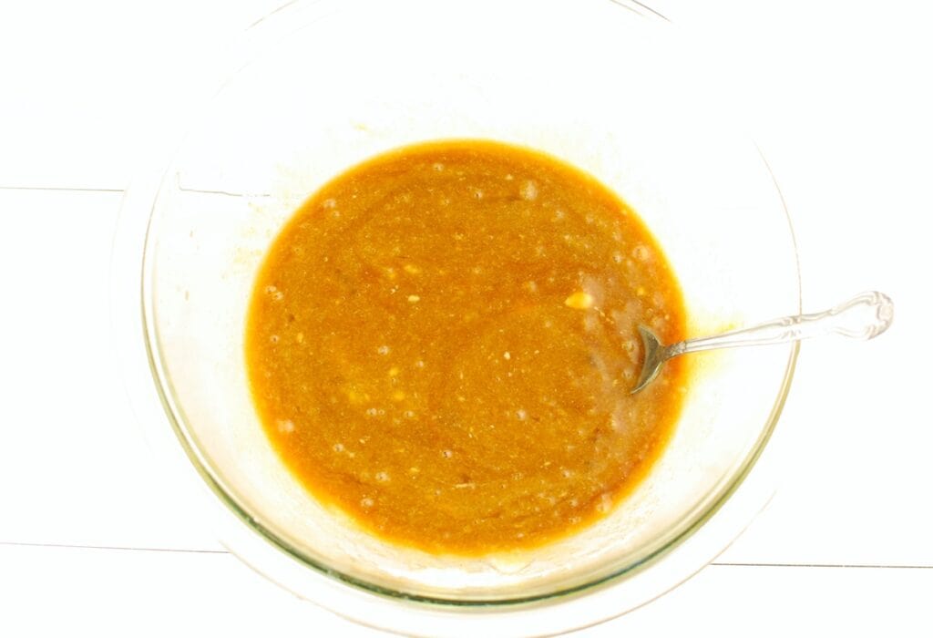 Dairy free butter, sugar, brown sugar, molasses, and eggs mixed together in a bowl.