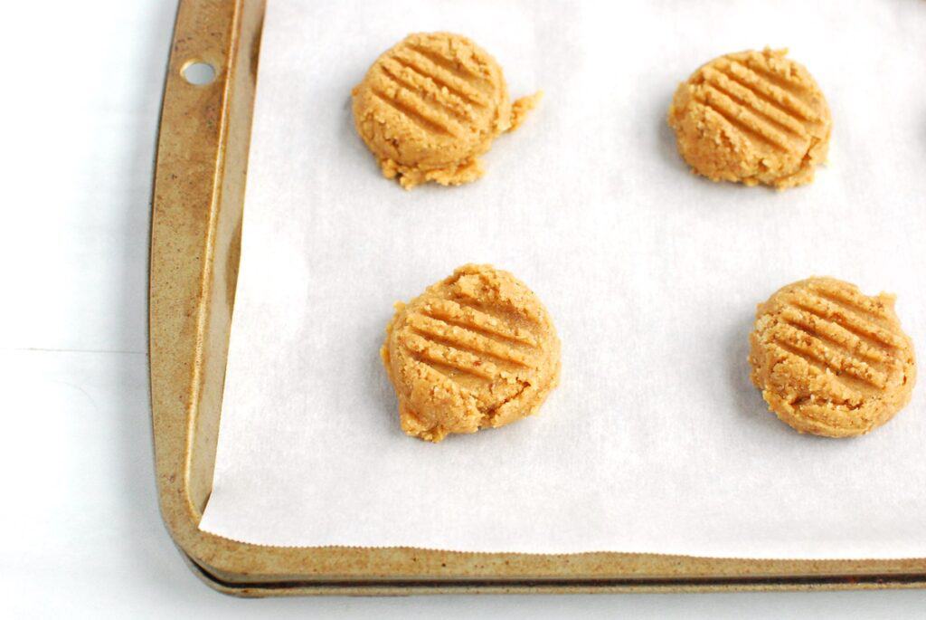 Cookie dough balls flattened slightly with a fork.
