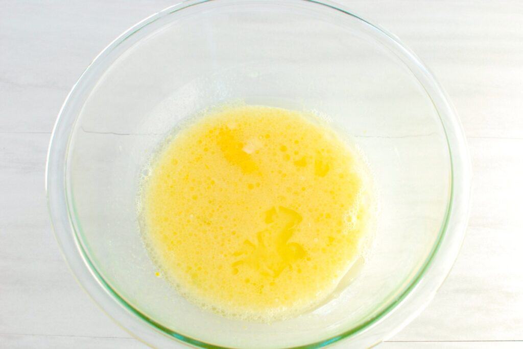 Almond milk, sugar, oil, and egg mixed together in a bowl.