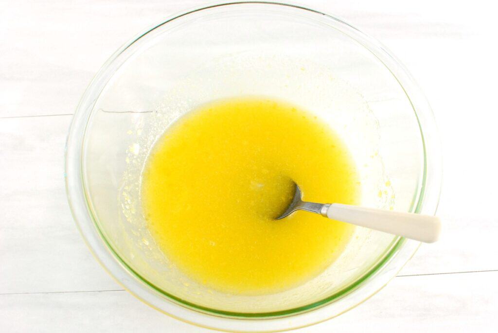 Olive oil, sugar, lemon juice, lemon zest, and olive oil mixed together in a bowl.