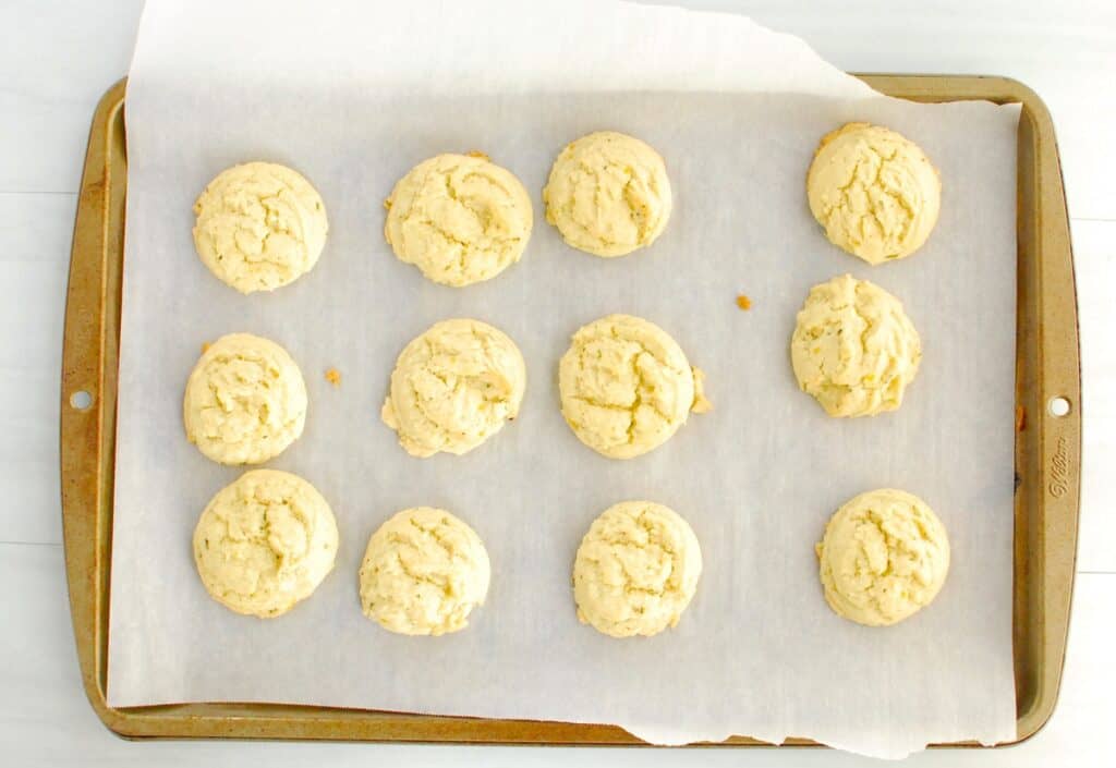 Just-baked lemon cookies on a baking sheet.