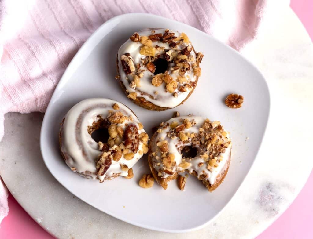 An overhead shot of three dairy free donuts on a plate.