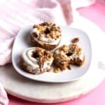 Three dairy free carrot cake donuts on a white plate.