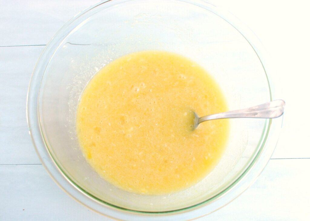 Sugar, dairy-free butter, oil, eggs, vanilla, and almond extract mixed together in a bowl.
