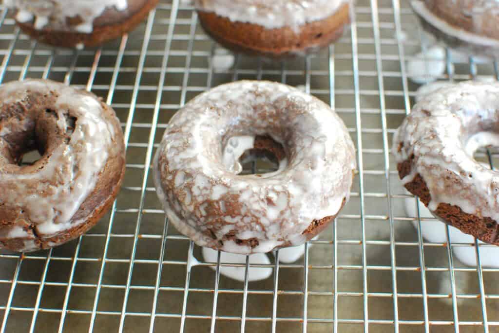 Dairy free chocolate glazed donuts on a cooling rack.