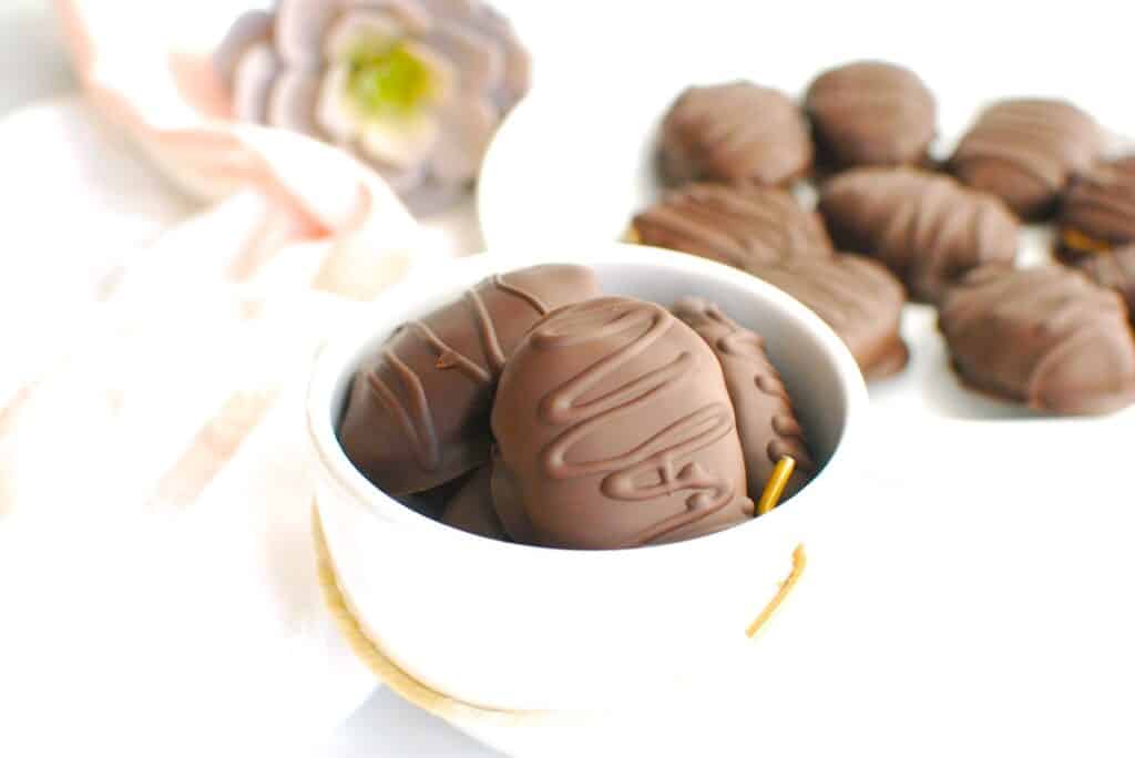 A small bowl filled with dairy free chocolate peanut butter eggs.