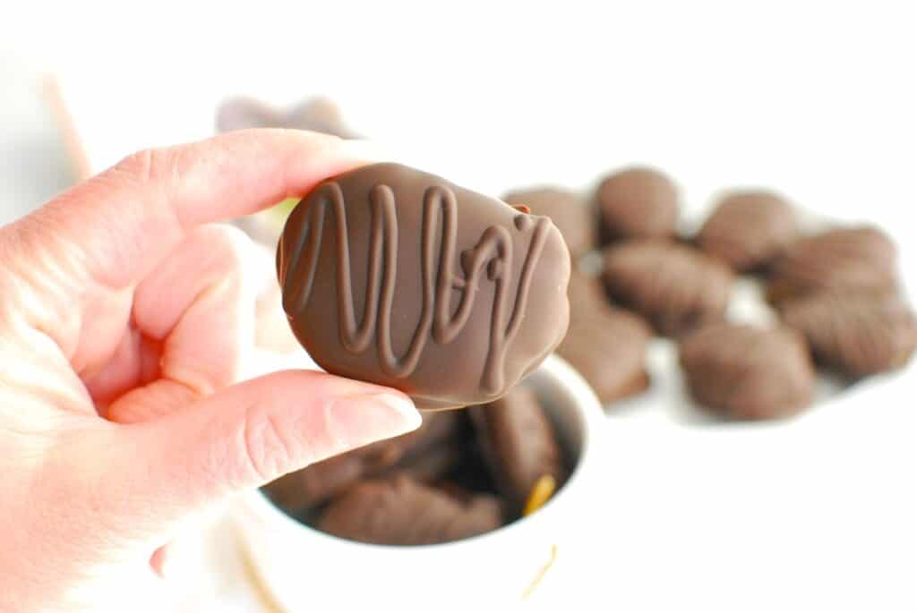 A woman's hand holding a dairy free homemade reeses egg.