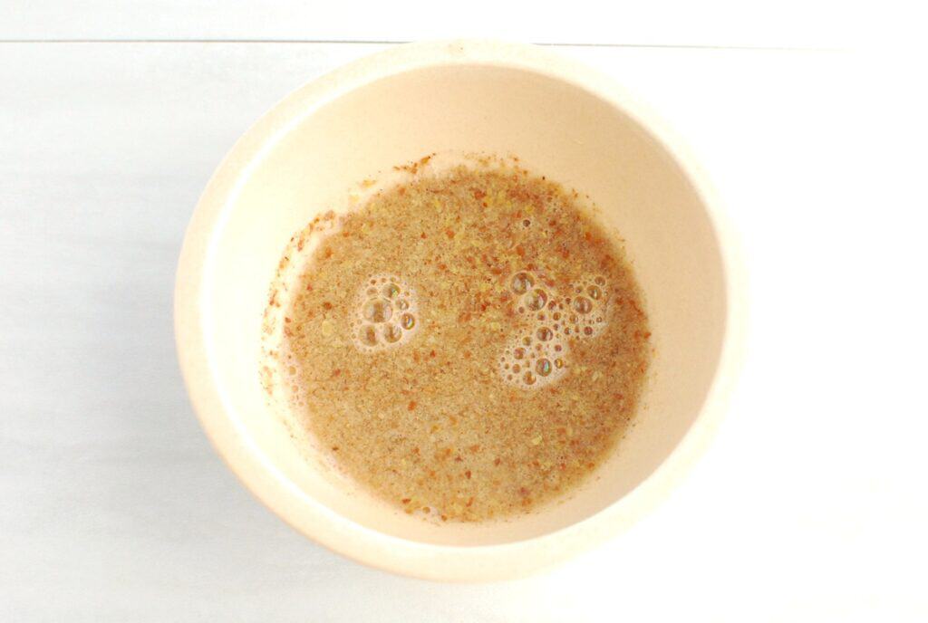 Ground flaxseed and water mixed in a small bowl.