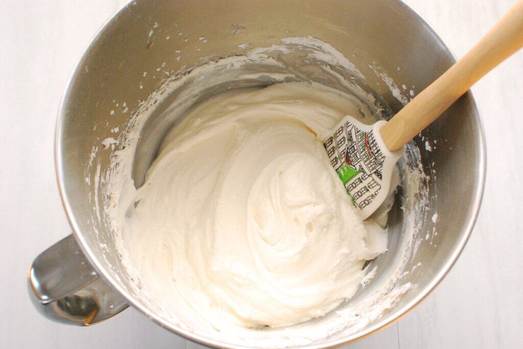 Dairy-free cream cheese frosting in a silver mixing bowl.