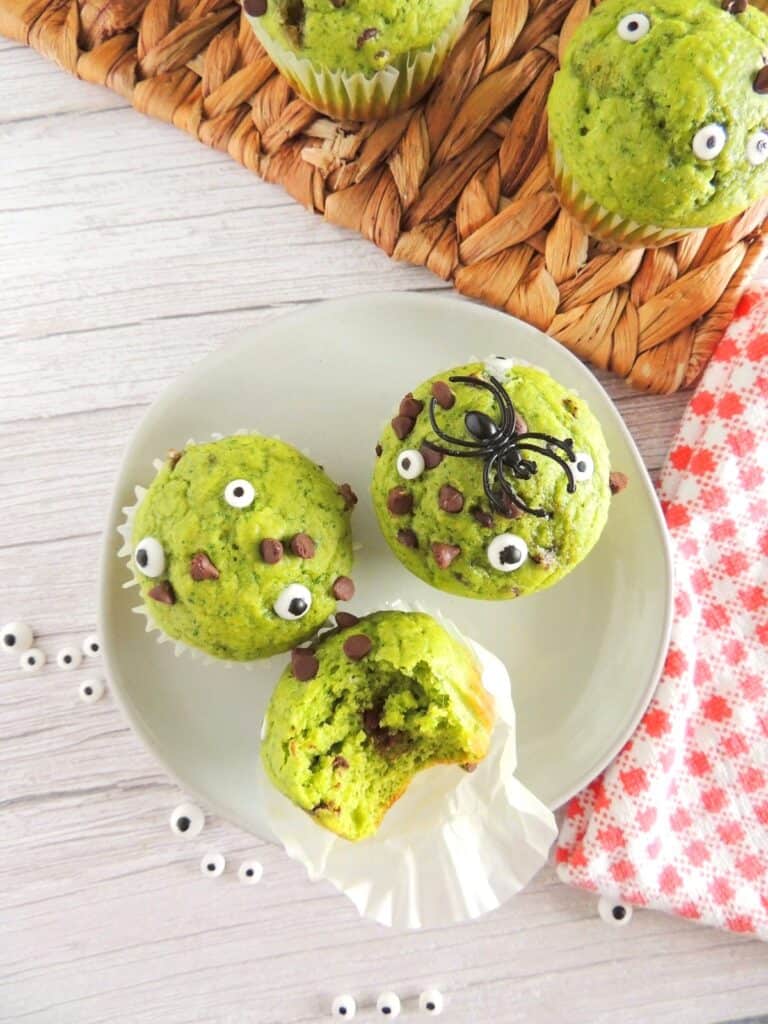 Three dairy free spinach muffins with edible eyeballs to look like monsters.