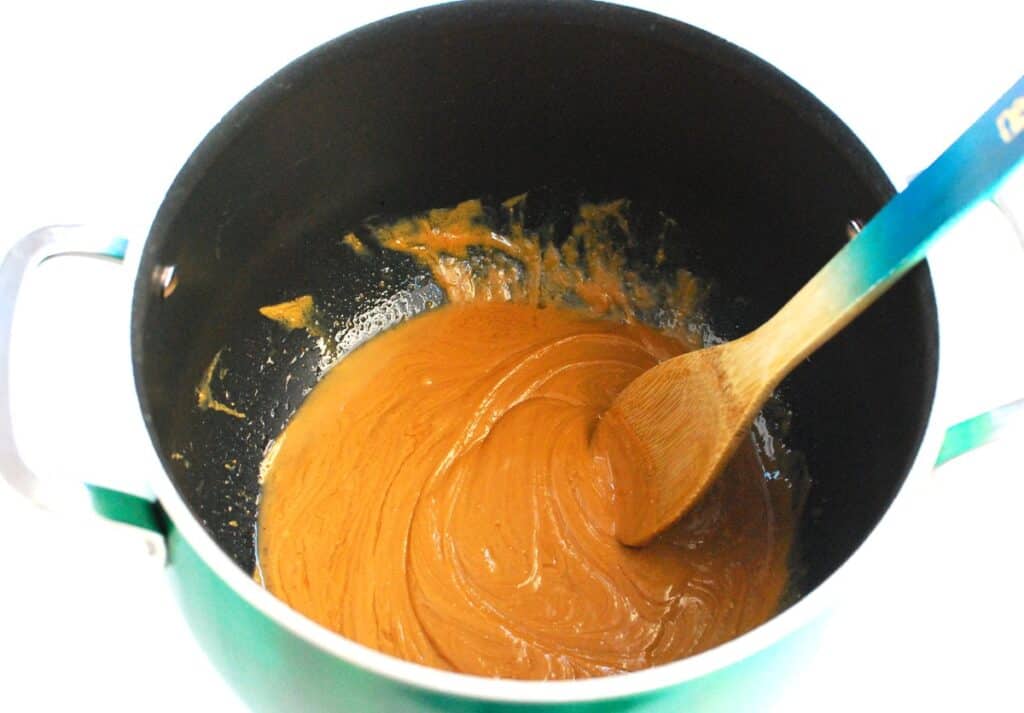 Peanut butter, honey, coconut oil, and vanilla combined in a large pot.