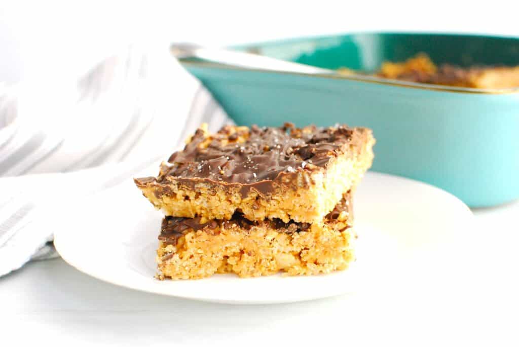 Two chocolate peanut butter rice krispie treats on a white plate.