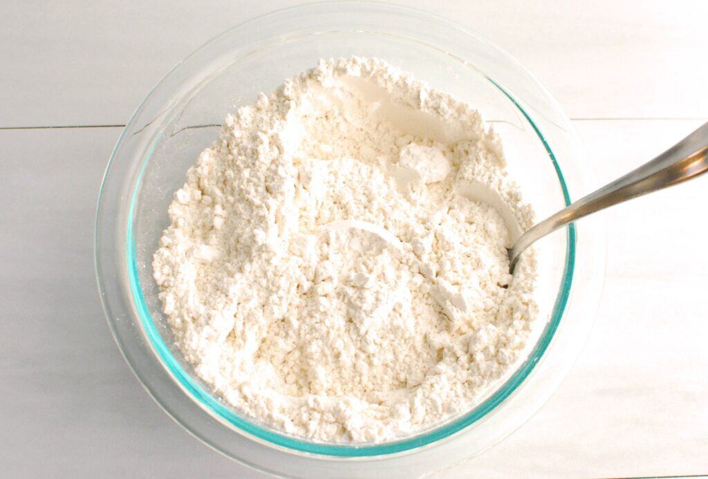 Flour, cornstarch, baking soda, and salt mixed together in a glass bowl.