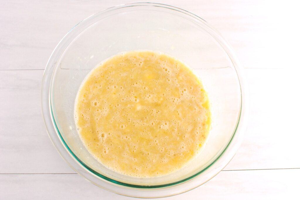 Bananas, eggs, almond milk, olive oil, brown sugar, and vanilla whisked together in a glass bowl.