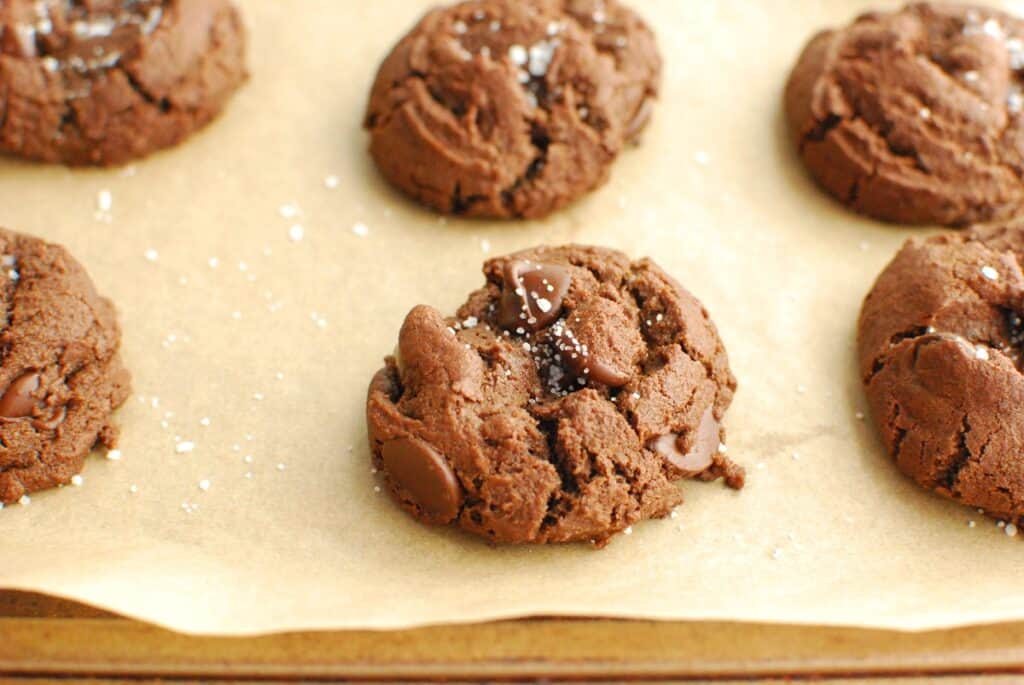 A close up of a double chocolate olive oil cookie sprinkled with sea salt.