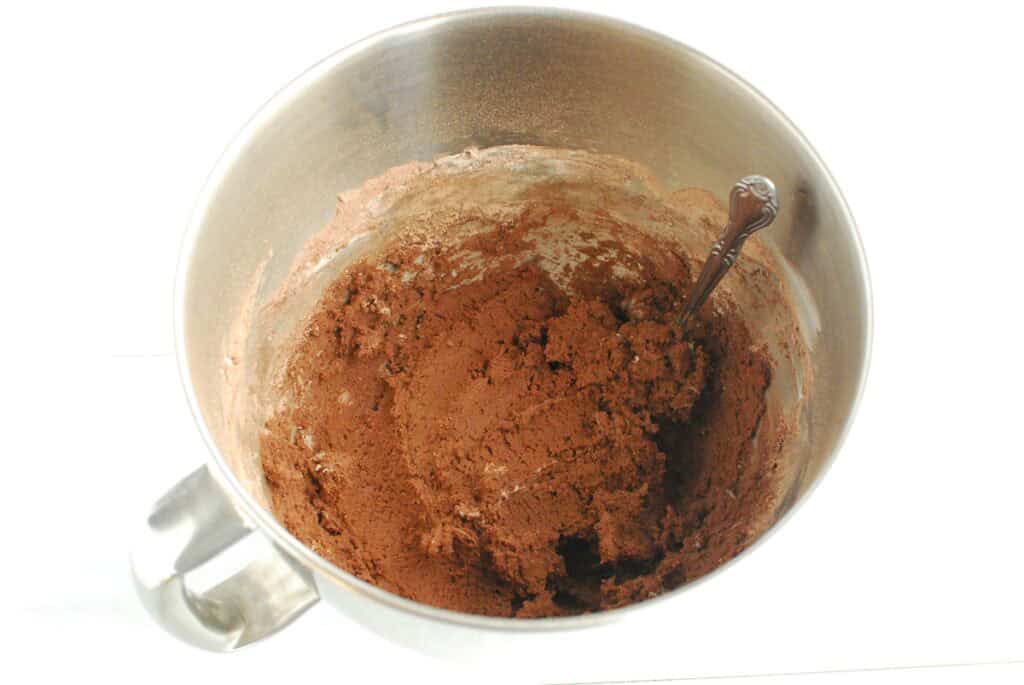 Chocolate cookie dough in a silver mixing bowl.
