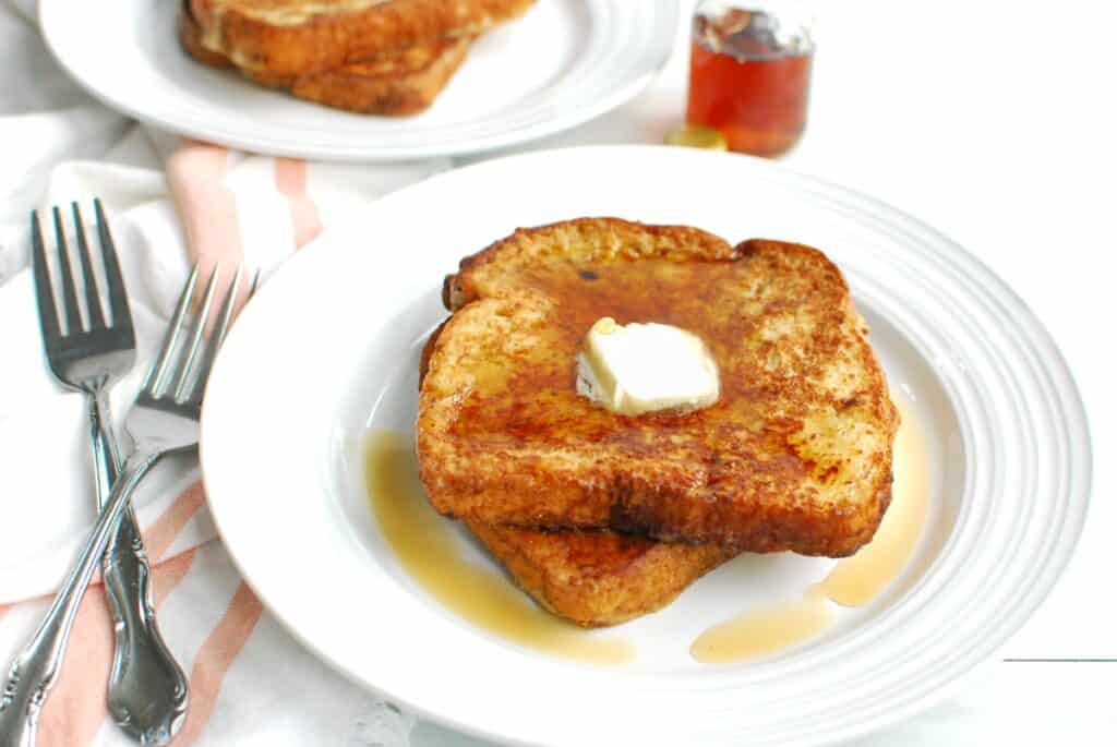 Dairy free ice cream french toast on a plate topped with syrup.