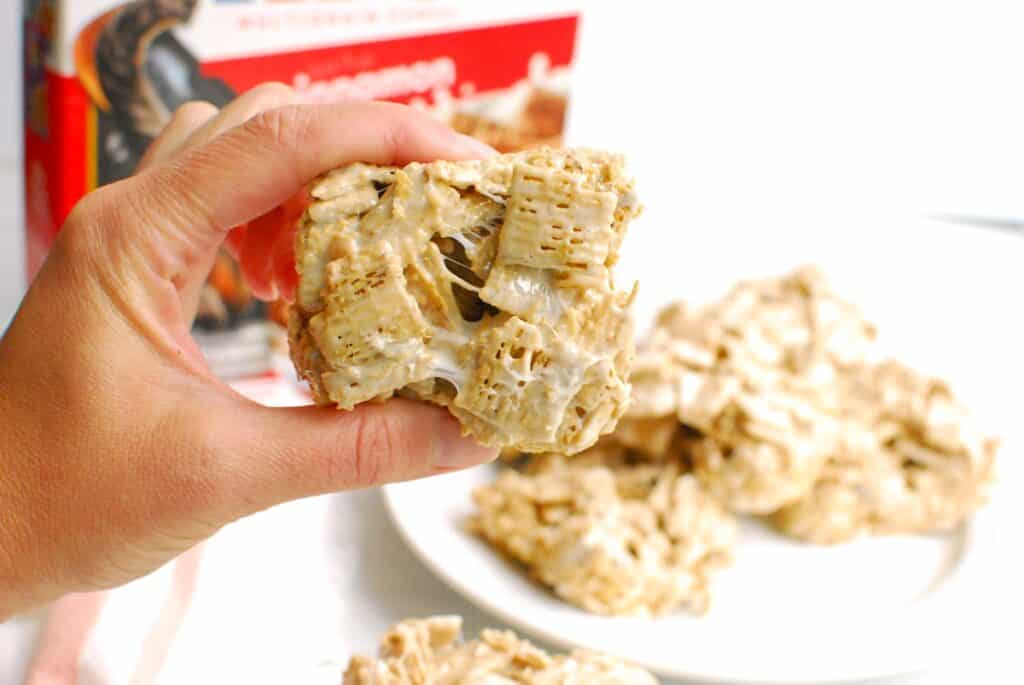 A woman's hand holding a cereal treat.