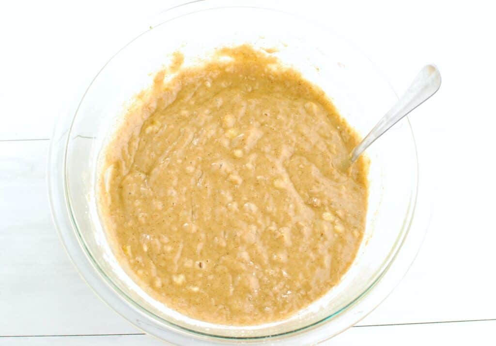 Banana cake batter in a glass mixing bowl.