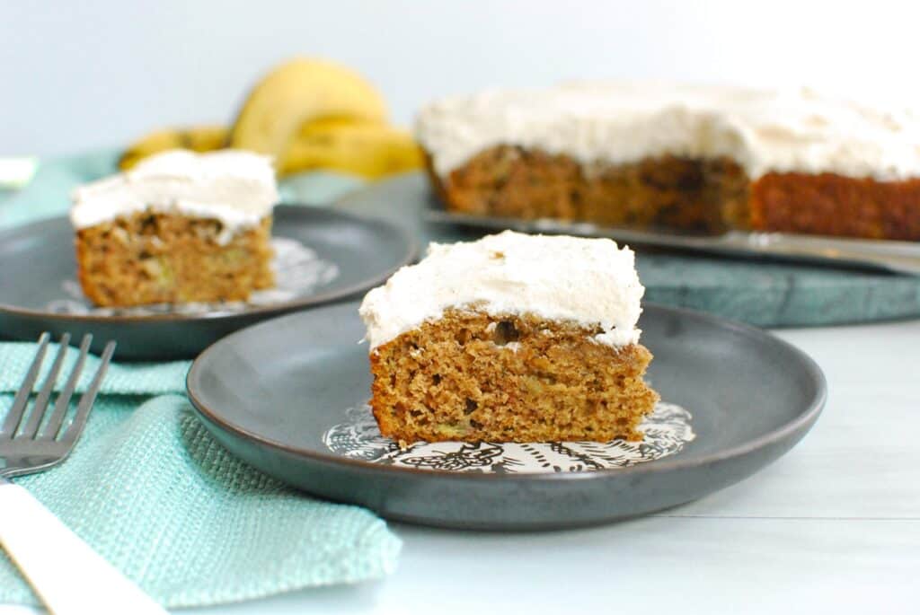 A slice of dairy free banana cake with dairy free cinnamon cream cheese frosting.